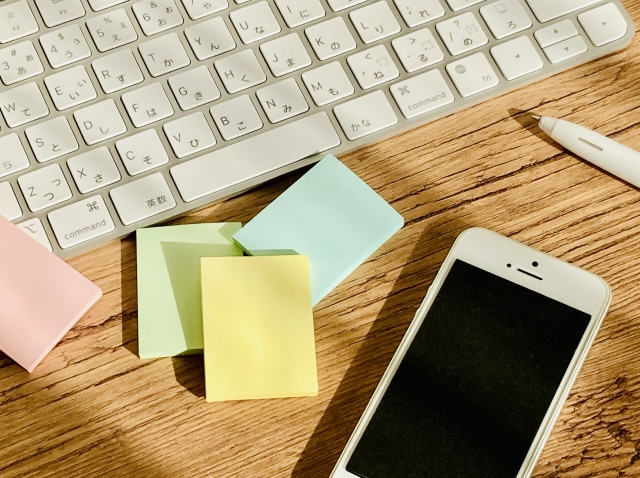 PCとスマホ、付箋などが机にある、勉強を連想させるイメージ